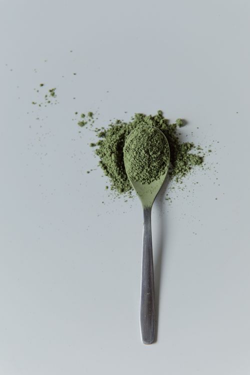 Sprouted Ragi Powder - fine green superfood powder on spoon